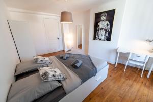 1 dormitorio con 2 camas, mesa y escritorio en KASA ZAMBEZE - Spacieux - WIFI, en Saint-Étienne