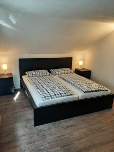 ein großes Bett in einem Zimmer mit zwei Nachttischen in der Unterkunft Ferienhaus -Alte Feuerwehr- Mittelndorf in Mittelndorf