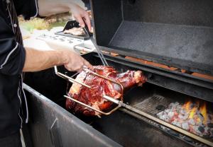 a person is cooking a turkey on a grill at Sportpenzion Pohoda in Pilsen