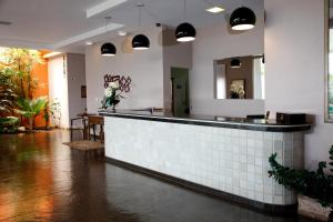 um restaurante com um balcão de azulejos e um espelho em Attiê Park Hotel em Uberlândia