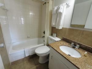 a bathroom with a toilet and a sink and a tub at White Marlin Inn - Virginia Beach in Virginia Beach +20 photos