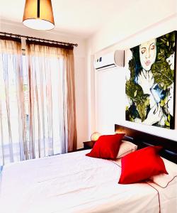 a bedroom with a bed with two red pillows at BALI SUITES 101 in Larnaca