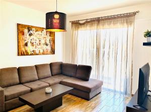 a living room with a brown couch and a table at BALI SUITES 101 in Larnaka