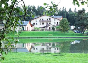 a house sitting next to a body of water at Sportpenzion Pohoda in Pilsen