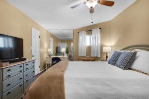 a bedroom with a large bed and a flat screen tv at Holiday Surf and Racquet Club 412 in Destin +36 photos