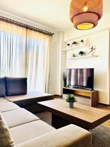 a living room with a couch and a flat screen tv at BALI SUITES 303 in Larnaca