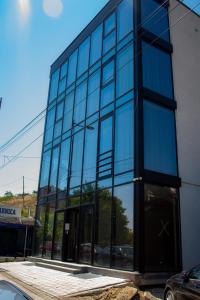 un gran edificio de cristal con una puerta giratoria en Glass Apartmani, en Novi Pazar