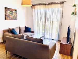 a living room with a couch and a tv at BALI SUITES 404 in Larnaca