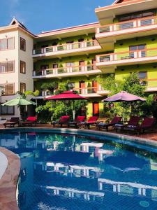 a hotel with a swimming pool in front of a building at The Moon Kampot Boutique in Kampot