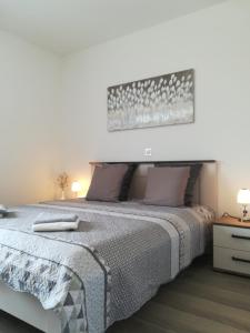 a bedroom with a large bed and two lamps at Apartment Villa Bijele Stijene in Karlobag +25 photos