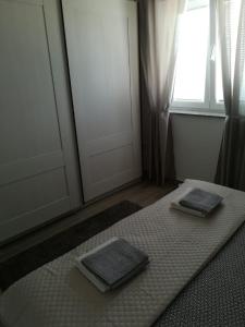 a room with two towels on a bed with a window at Apartment Villa Bijele Stijene in Karlobag