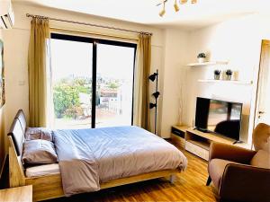 a bedroom with a bed and a large window at BALI SUITES 505 in Larnaka +9 photos