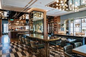 a restaurant with tables and chairs and a bar at Sofitel Adelaide in Adelaide