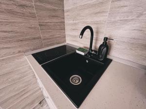 a black sink in a bathroom with a counter at Central Park Studio in Onești +16 photos