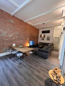 a living room with a brick wall and a table at Luxus Citywohnung in Hannover in Hannover