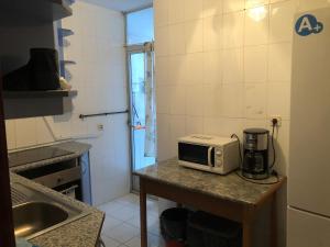 a kitchen with a counter with a microwave on a table at Paris in Alcalá de Henares +5 photos
