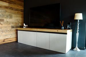 a large flat screen tv on top of a wooden wall at Le Volpi Luxury Apartments in Gressan