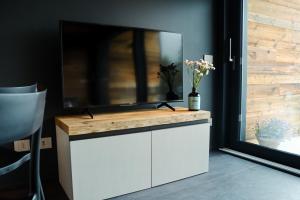 soggiorno con TV su un armadietto bianco di Le Volpi Luxury Apartments a Gressan