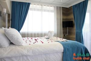 埃德雷米特的住宿－Mas Butik Otel，一间卧室,床上放着鲜花