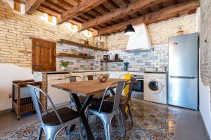 a kitchen with a table and chairs and a refrigerator at Casa rural Mestre in Deltebre