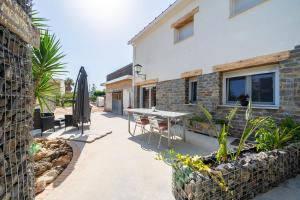 a patio with a table and a building at Casa rural Mestre in Deltebre