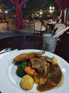 een bord met vlees en groenten op tafel bij Sir Francis Drake in Heatherbrae
