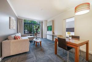 a living room with a couch and a table at Harbourside Pool Escape with Leafy Alfresco Patio in Darwin