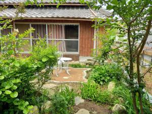 a garden with a table in front of a house at Neko Neko La Campagne in Tamba