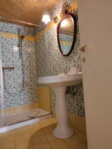 a bathroom with a sink and a shower with a mirror at B&B Il Caminetto in Matera