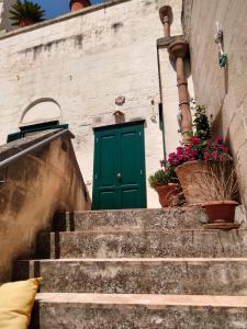 a green door on the side of a building with stairs at B&B Il Caminetto in Matera