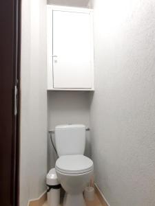 a bathroom with a white toilet and a cabinet at Mazeikiai Apartment in Mažeikiai