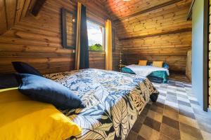 um quarto com uma cama num chalé de madeira em Charmant chalet avec jacuzzi, L'île Ô Vert em Saint-Philippe