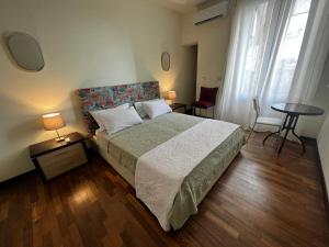 een slaapkamer met een bed en een tafel en stoelen bij Al Castello in Catania