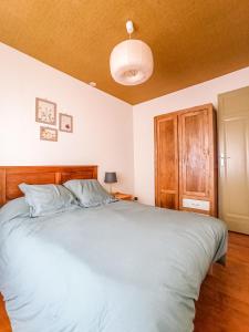 sypialnia z dużym łóżkiem z drewnianym zagłówkiem w obiekcie Maison de montagne proche Gavarnie 12-14 personnes w mieście Gèdre