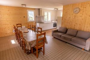 Maison de montagne proche Gavarnie 12-14 personnes في جيدريه: مطبخ وغرفة طعام مع طاولة وأريكة