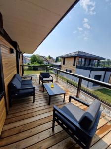 una terraza de madera con sofás y una mesa. en Villa Laba en Yvoire