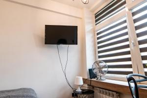 1 dormitorio con TV y ventana con ventilador en Komfortowy apartament ścisłe centrum Radom en Radom