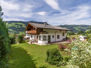 a house on a hill with a green yard at Landhaus Brixental in Westendorf