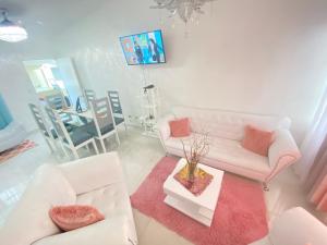 a living room with two white couches and a table at 7 Santiago Minumental Area Lovely Specially 4 You - Cozy 3 bedrooms WIFI- Caribe tours - Colinas Mall and transportation 24 hours Apartment for 7 peoples in Marilópez