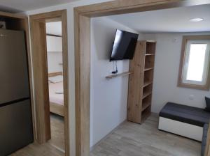 a small room with a tv and a bedroom at Mobile homes King, Camp Dida in Pirovac