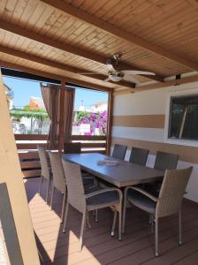 a dining table and chairs on a deck at Mobile homes King, Camp Dida in Pirovac