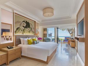 a bedroom with a large bed and a living room at Dusit Thani Laguna Phuket in Bang Tao Beach