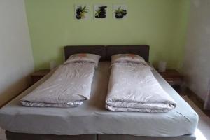 a bed with white sheets and pillows in a room at Ferienwohnung Groß Laichingen in Laichingen