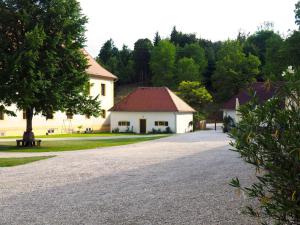 uma entrada que leva a uma casa branca com uma árvore em Schloss Ehrenfels em Hayingen
