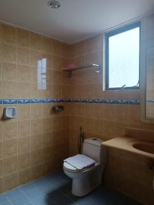 a bathroom with a toilet and a sink and a window at HOTEL AMBASSADOR 2 in Labuan +11 photos