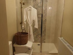 a bathroom with a shower with a white robe on a toilet at Escapade de charme près de Verdun : cocon pour 2 personnes avec cuisine équipée et balades à proximité - FR-1-585-85 in Souilly