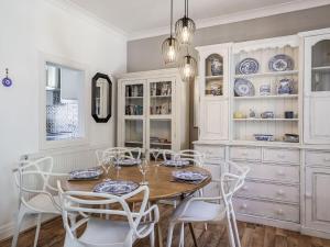 a dining room with a wooden table and white chairs at Granary Cottage in Pembroke