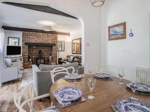 a living room with a table and chairs and a fireplace at Granary Cottage in Pembroke