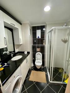 a bathroom with a toilet and a sink and a shower at Modern 2bedroom apt on Cleopatra (WiFi,pool) in Alanya