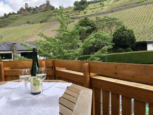 een fles wijn op een tafel met wijnglazen bij Ferienwohnung Herold in Alken